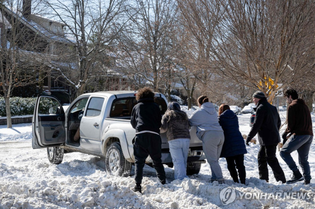 미 켄터키주 루이빌에서 폭설 속에 고립된 차량 치우는 주민들 